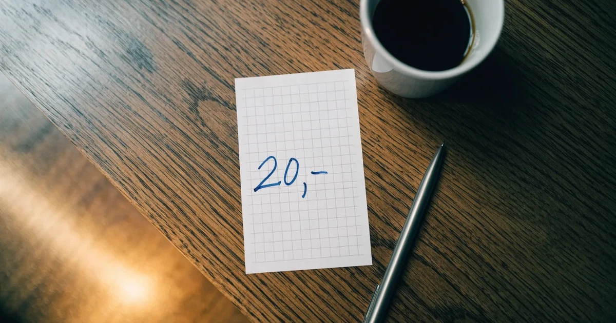 Ein leerer Wettschein aus Papier liegt neben einem Kugelschreiber und einer Tasse Kaffee auf einem Tisch, Aufnahme von oben.